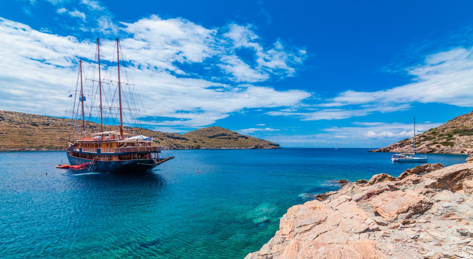 Variety Cruises ship anchored in turquoise waters next to rocky beach