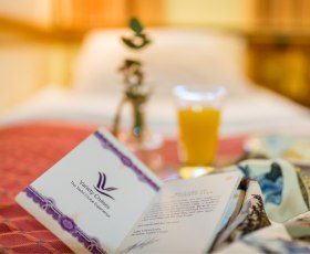 servises on board with a Variety Cruises welcoming card and a fresh orange juice in the background