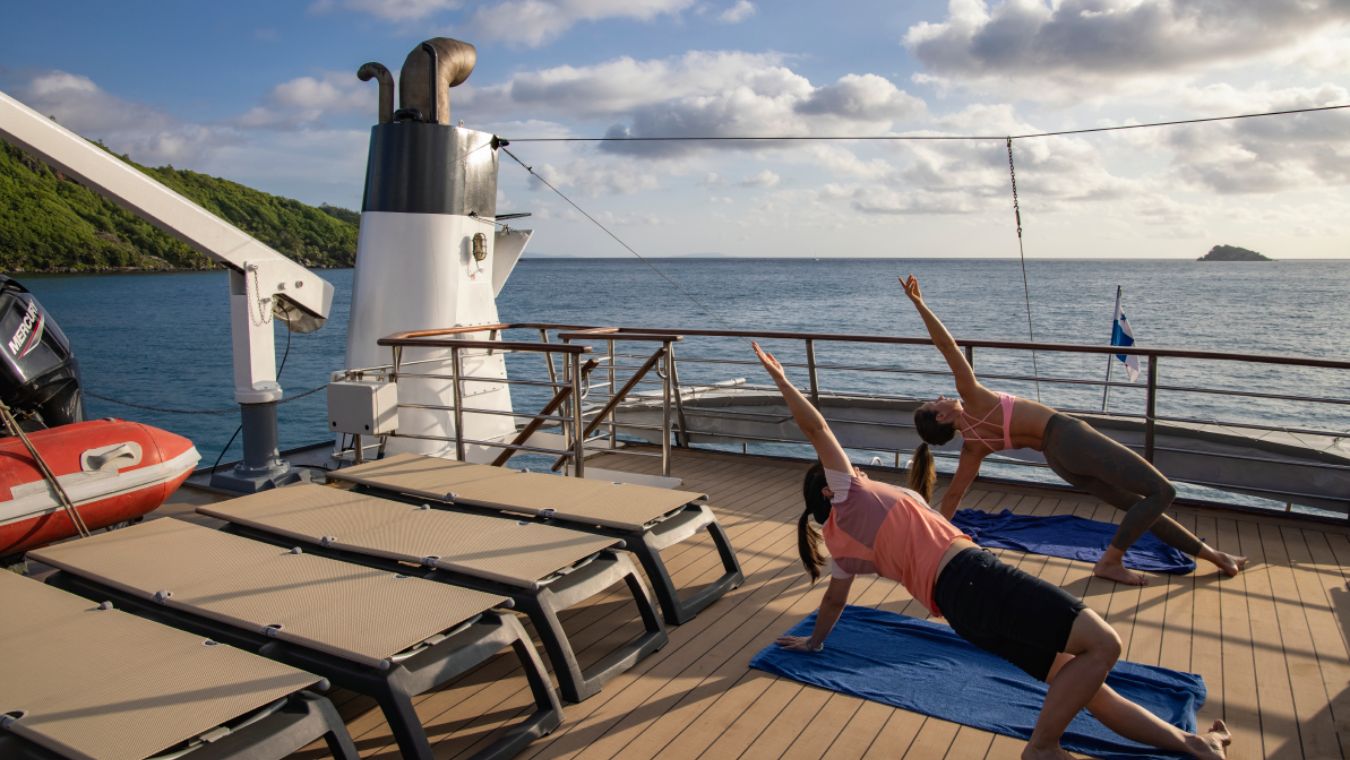 two women doing yoga on the deck of Variety Cruises' ship