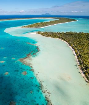 A view of Bora Bora island with mountains and the ocean in the background