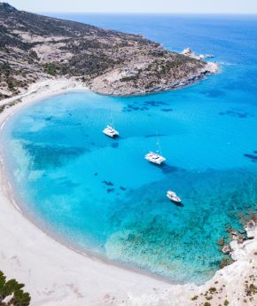 Aerial view of small ships in turquoise waters in a sandy beach