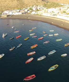 Boats floating next to a sandy beach in Cape Verde