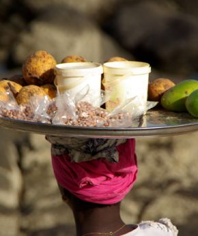 A woman selling local food on a plate
