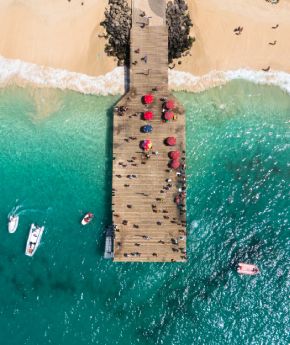 Aerial view of ships anchored next to sandy beach