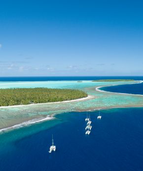 Aerial view of small ships in the ocean and tropical islands