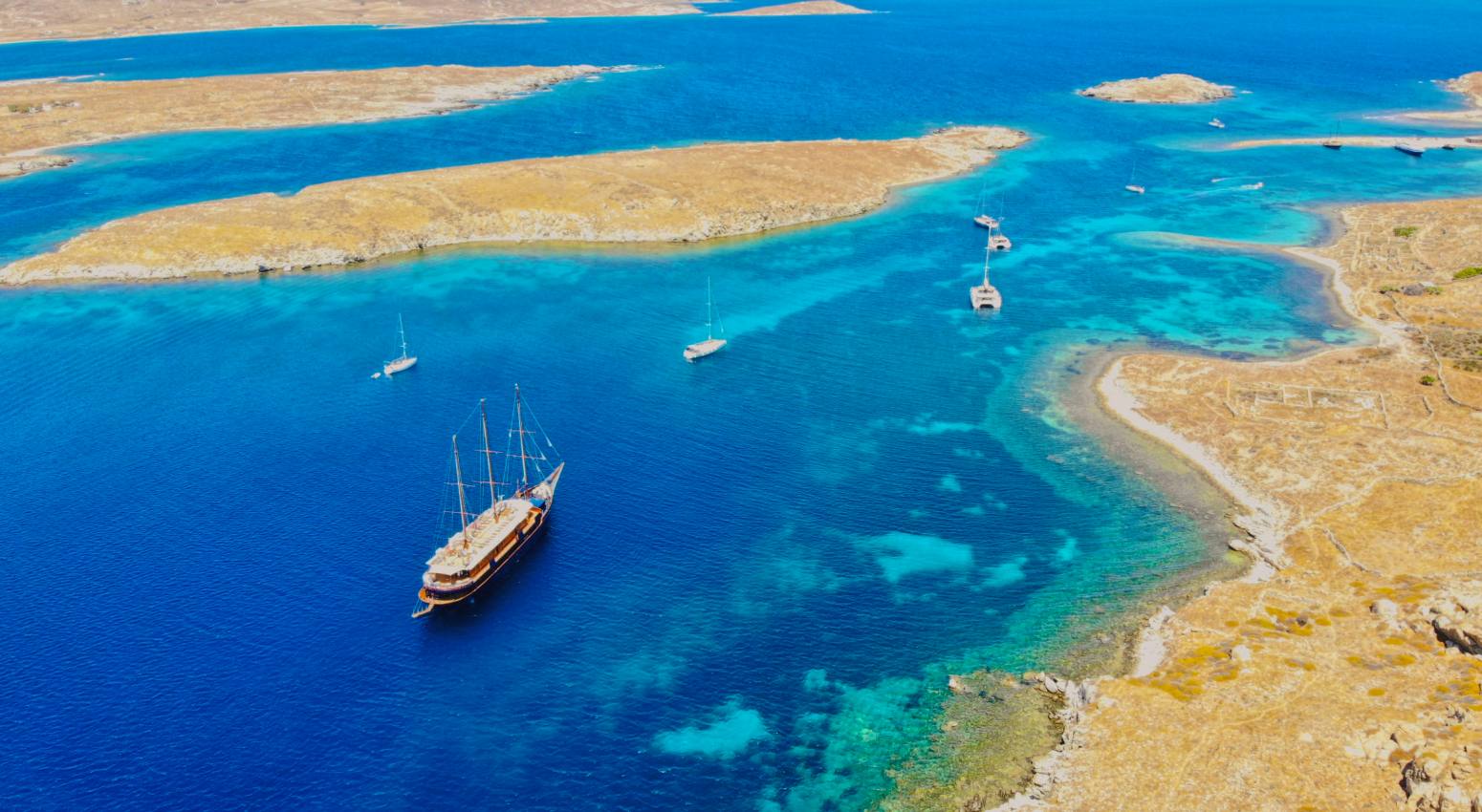 Aerial view of a small ship sailing through islands