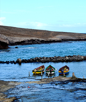 A beach with three fishing boats