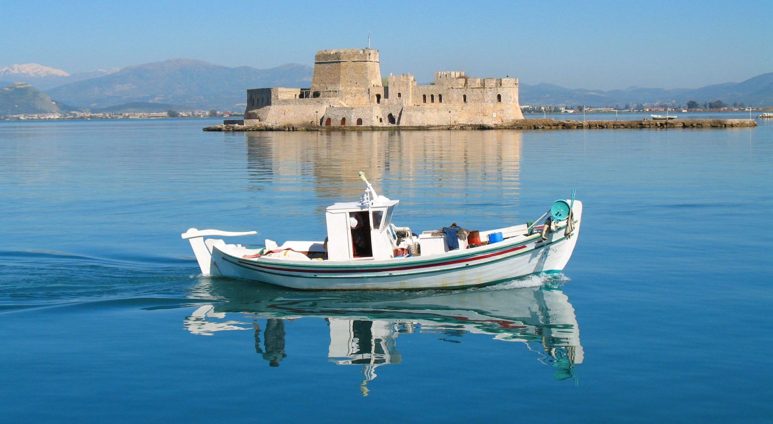 A local boat with Bourtzi Castle in Nafplion in the background