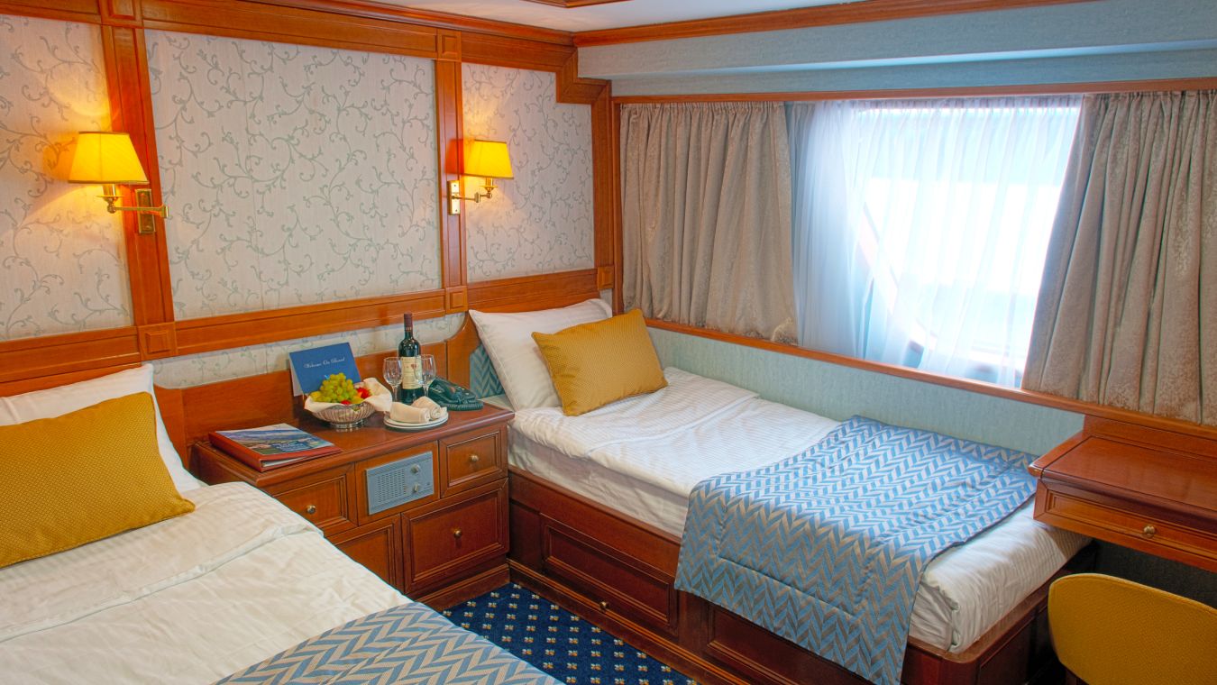 A twin cabin on the Callisto cruise ship with portholes