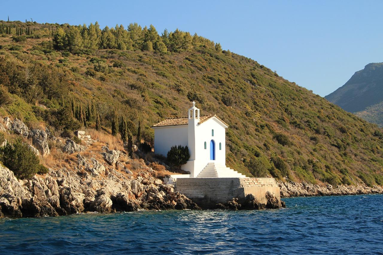 Traditional white and blue church in Santorini with caldera on the background