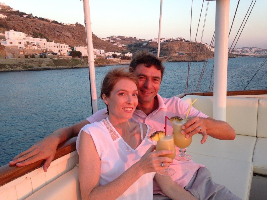 A stunning sunset view on board a Variety Cruises' yacht, with a couple drinking delicious cocktails