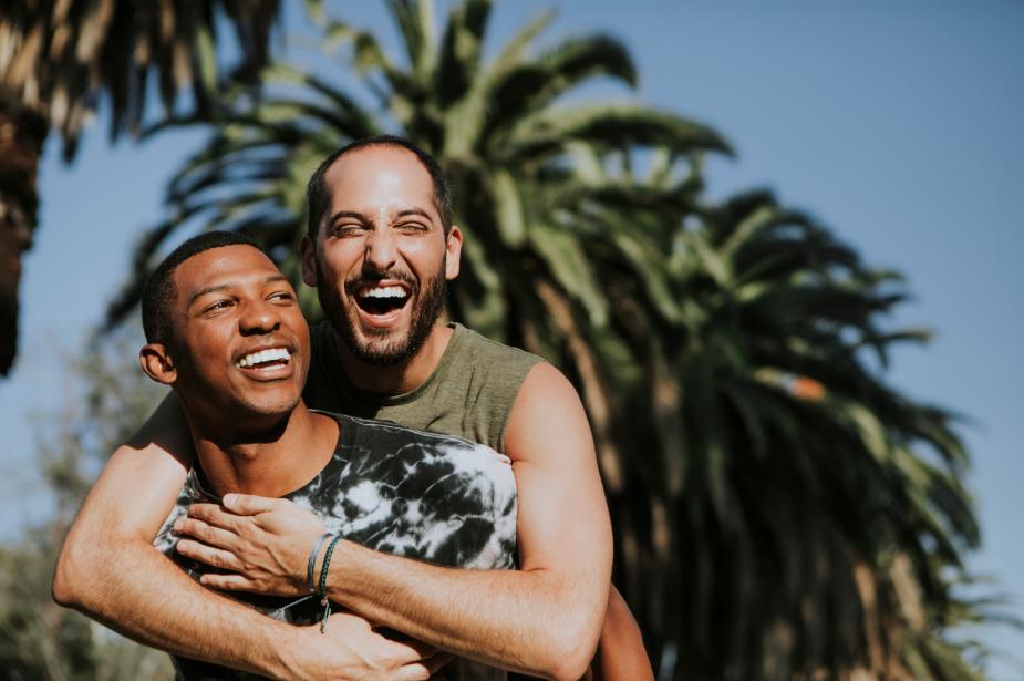 Two people hugging and smiling with a tropical island in the background