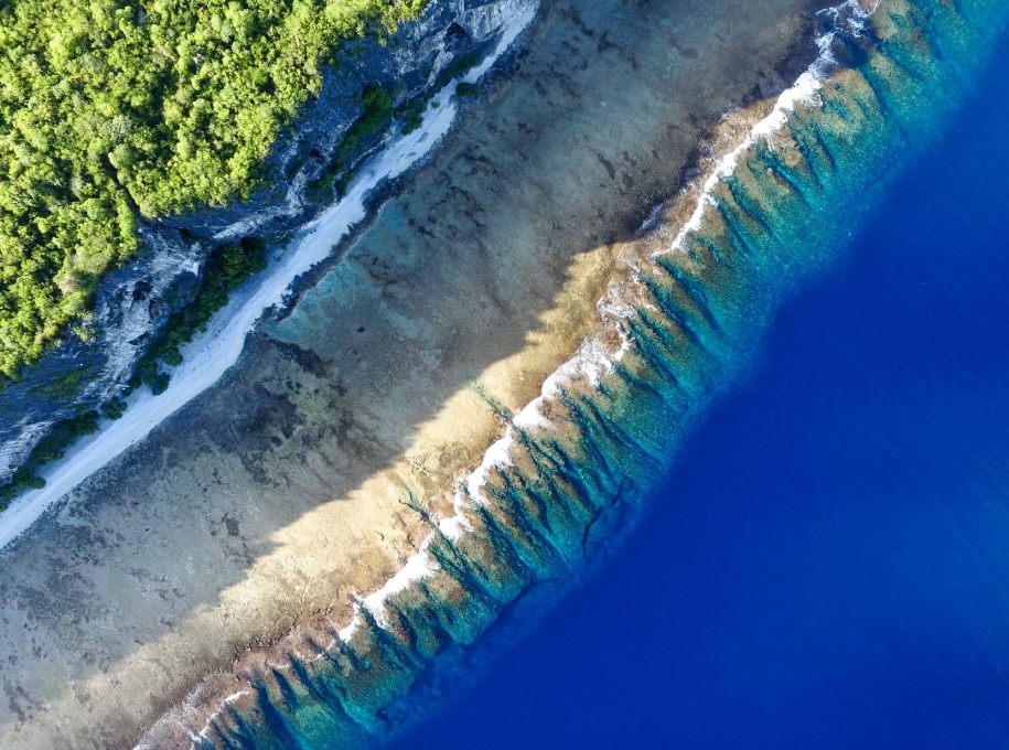 Aerial view of Makatea island's turquoise lagoon and tropical forest