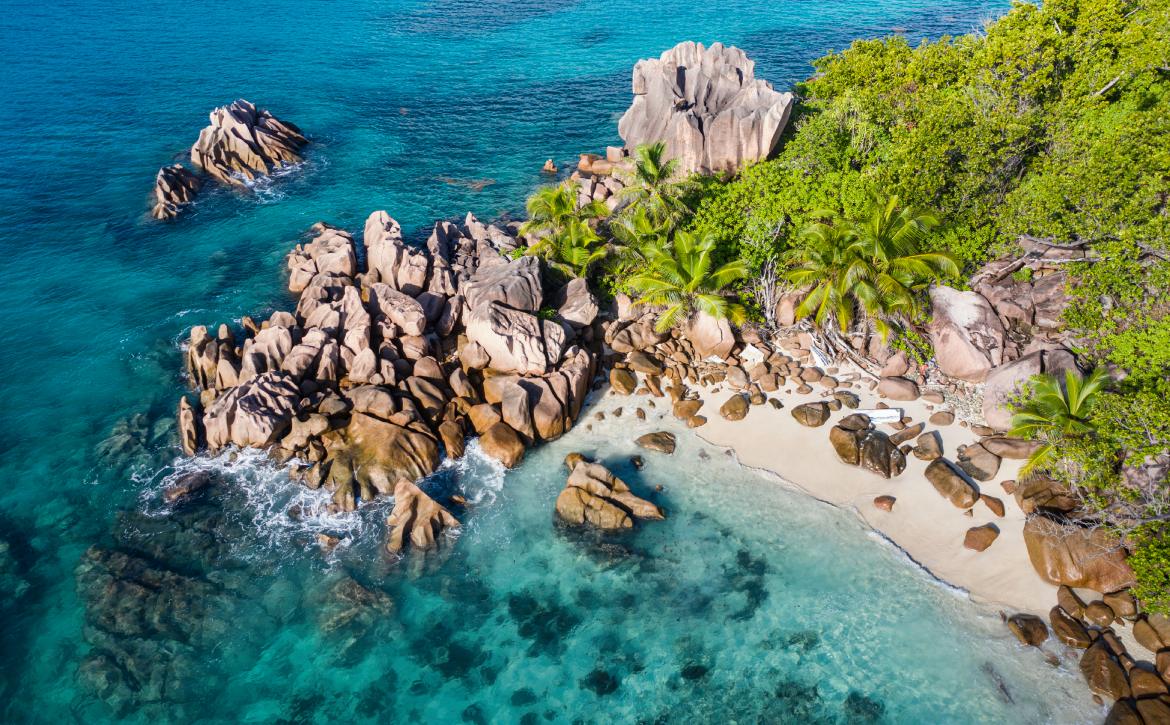 Aerial view of a beautiful beach with crystal clear waters in a rocky tropical beach