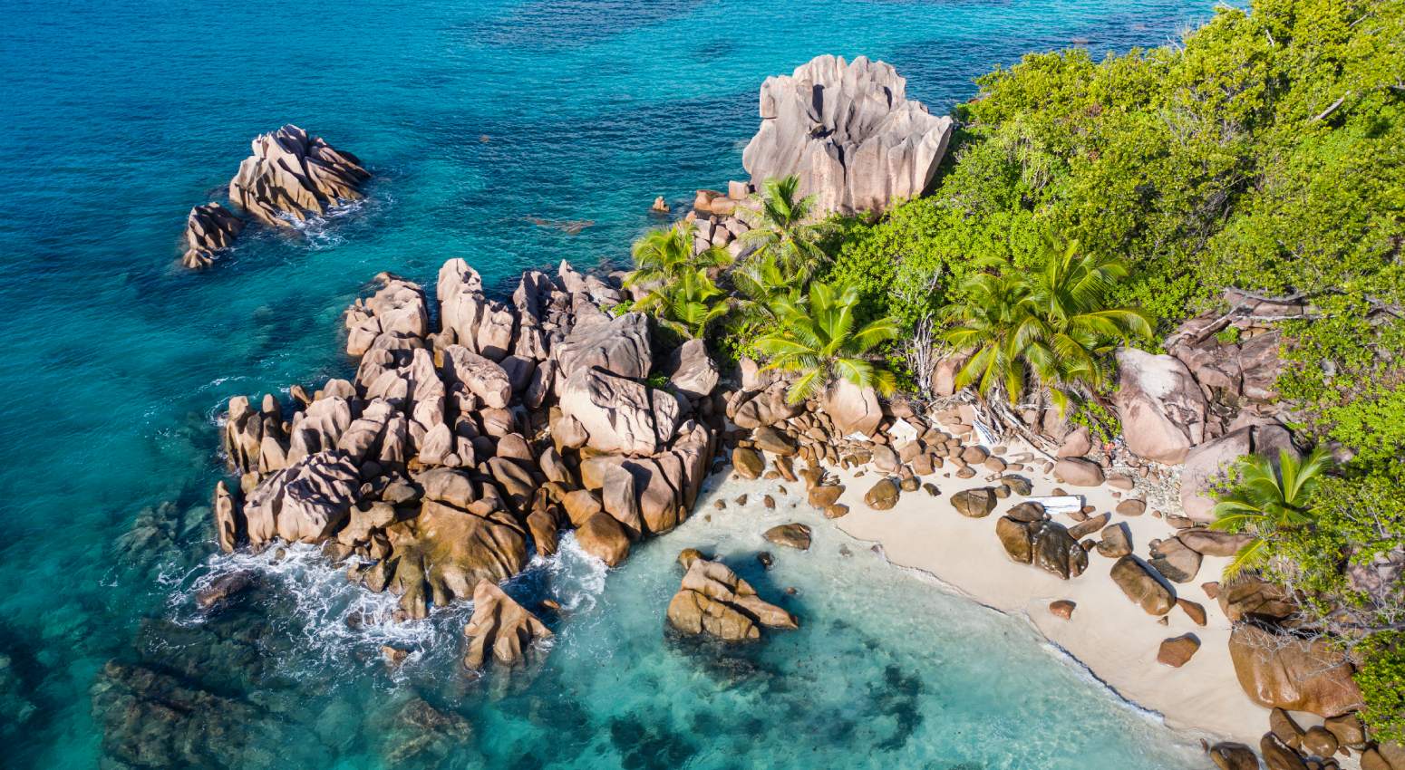 Aerial view of rocky cliffs and sandy beach in a tropical island