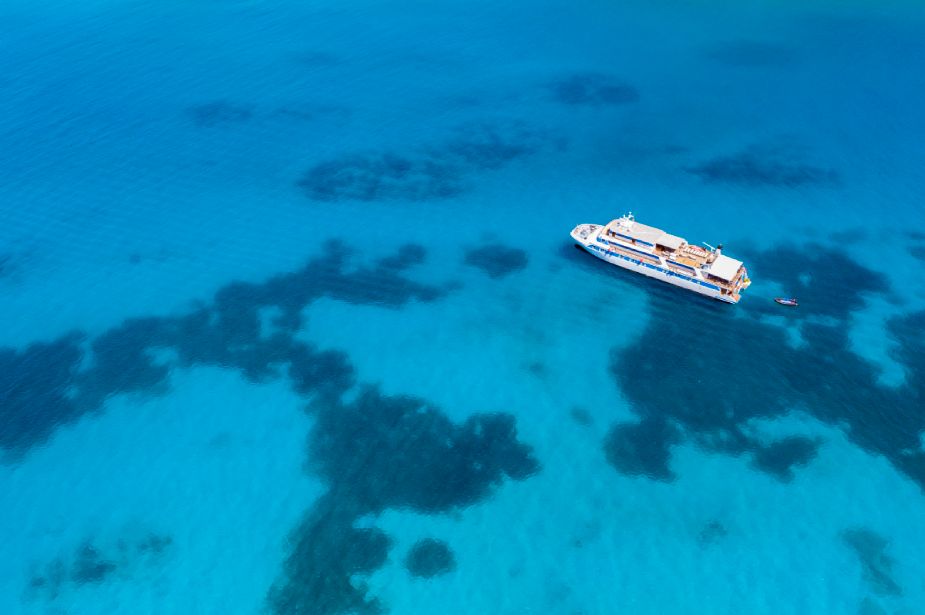 Aerial view of a Variety Cruises small ship sailing in turquoise waters