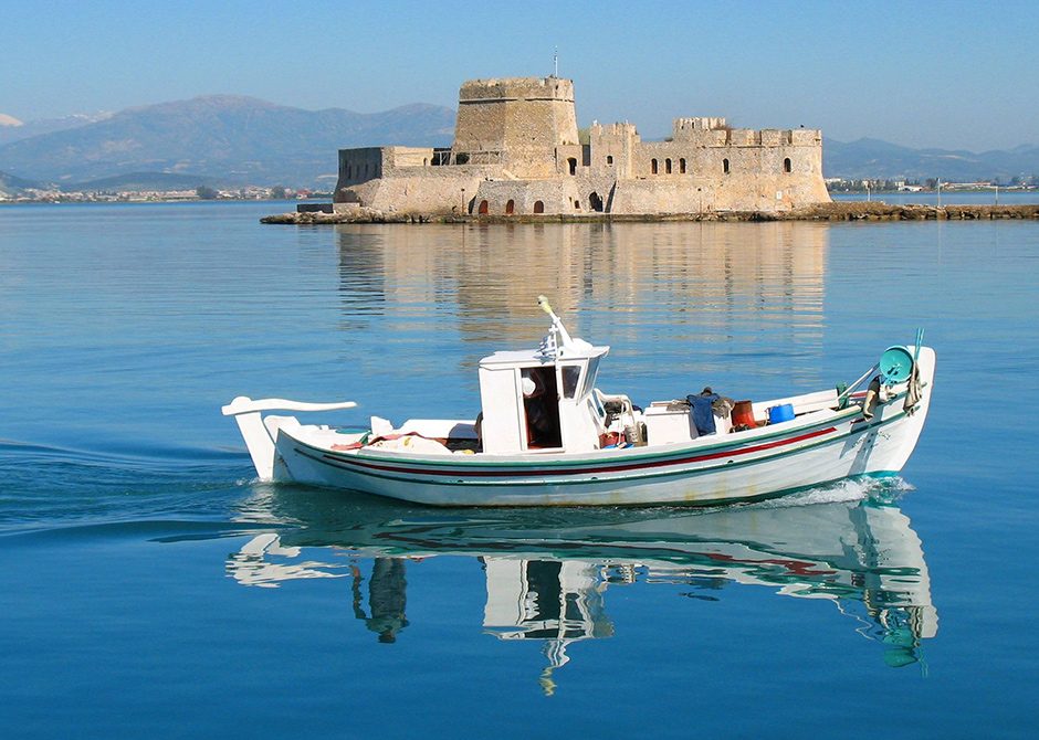 A view of the town of Nafplion, Greece from the sea with a small ship in the foreground