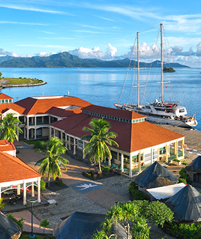 a ship anchored in a port of a tropical island