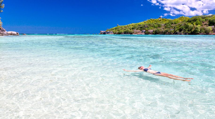 A person swimming in turquoise waters in Seychelles
