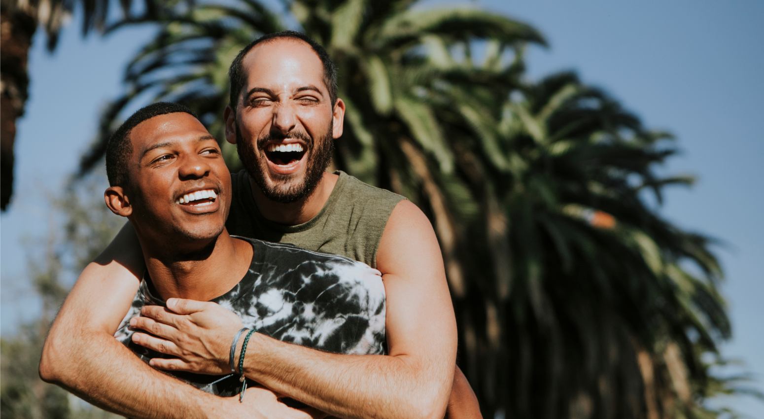 Two people smiling and hugging in a tropical island
