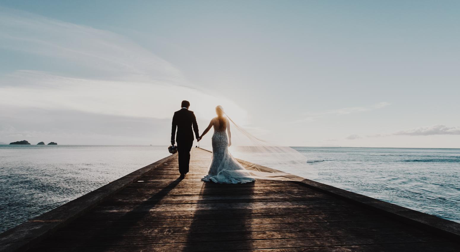 A couple holding hands and staring the sunset