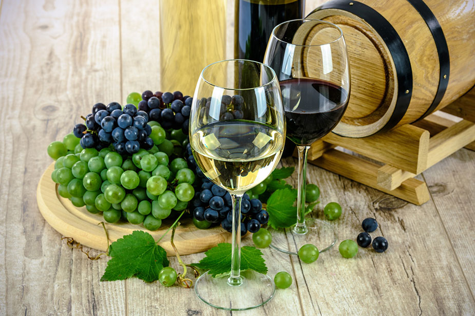 Close up of wine tasting session with two glasses of wine and grapes in a plate