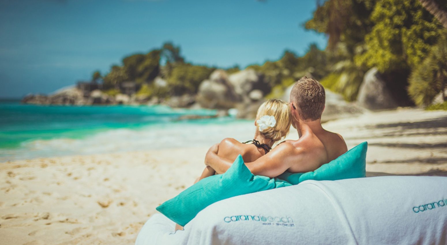 A couple relaxing in a tropical beach staring at the sea