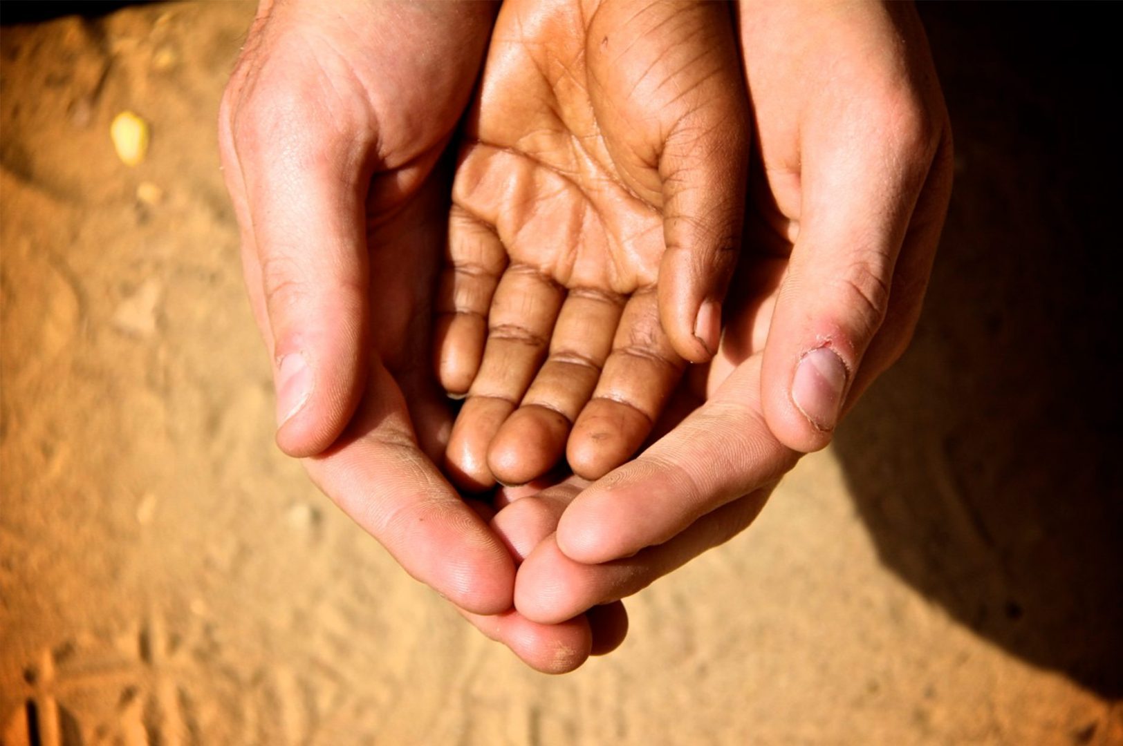 A kid's hand in adults's hands