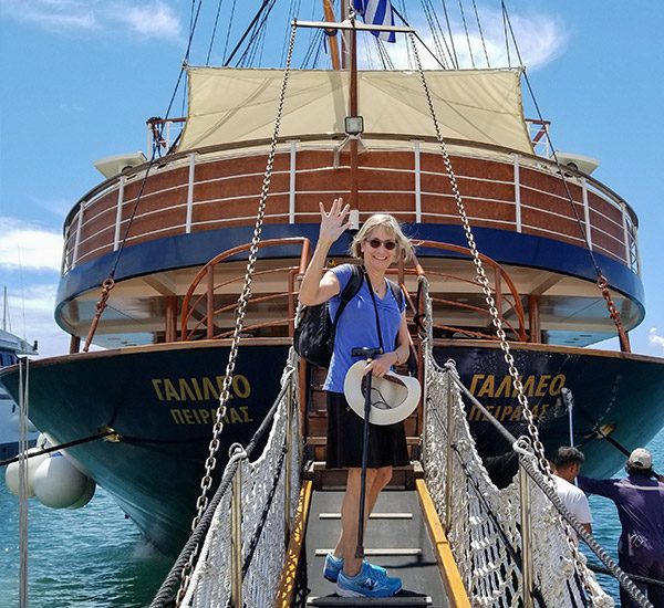 A woman waving in front of a cruise ship