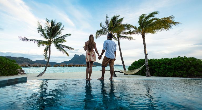 Tahiti and Bora Bora a couple holding hands looking at the sea