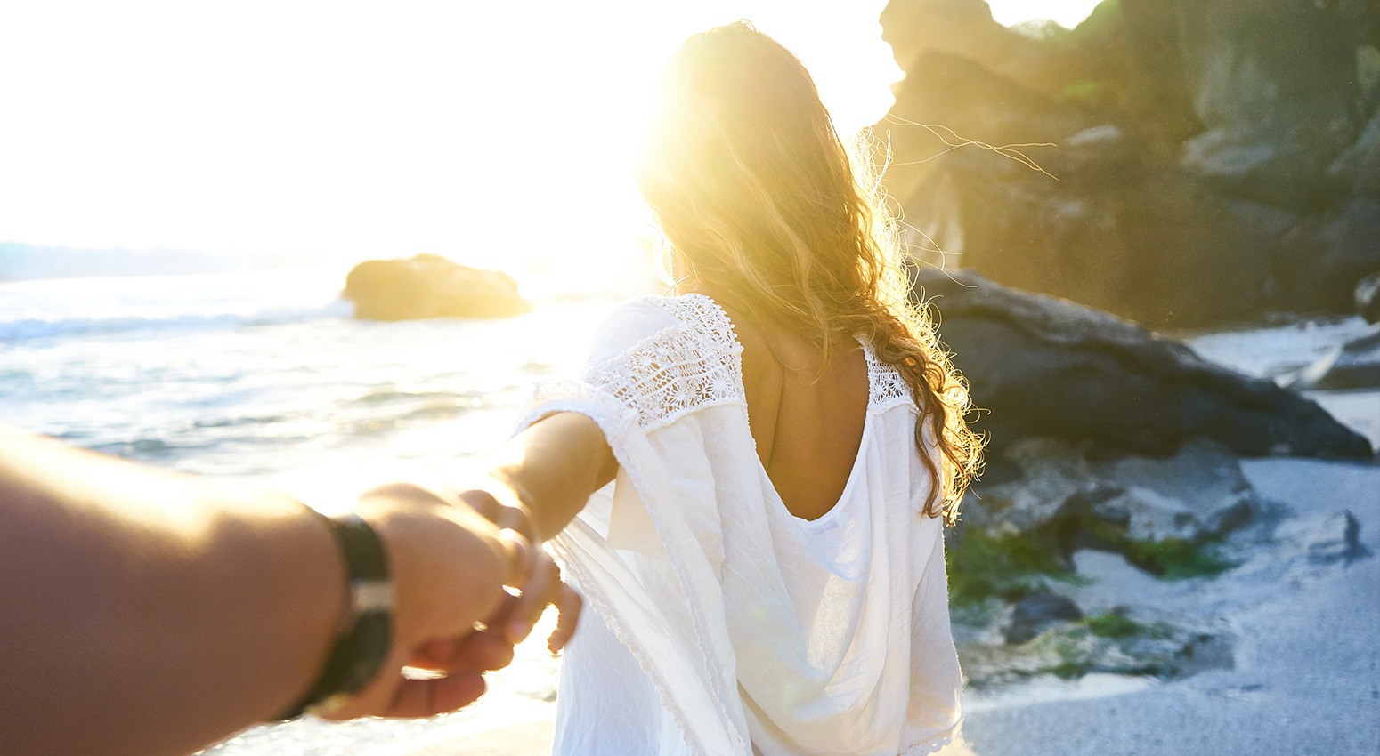 A couple holding hands and looking at the sunset