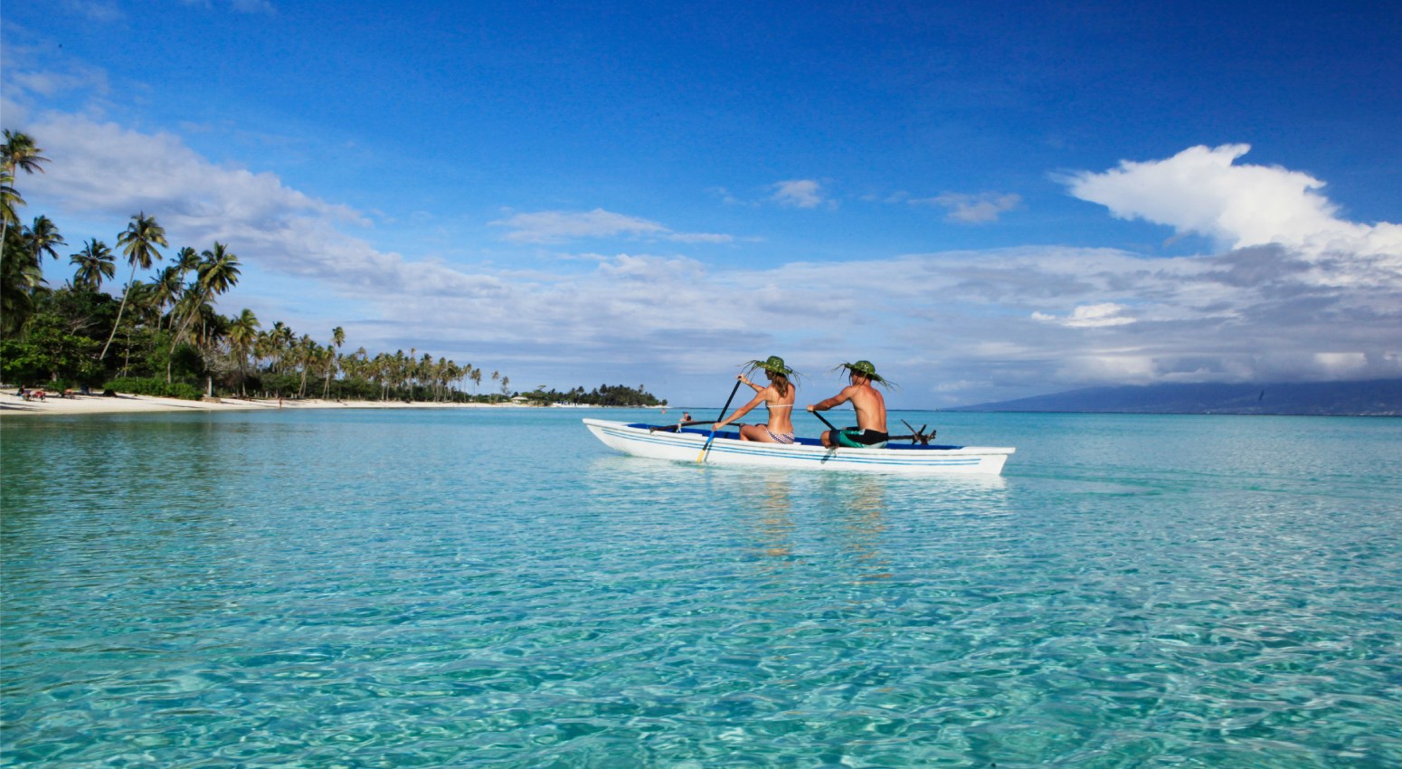 Couple on a small boat on turquoise waters.