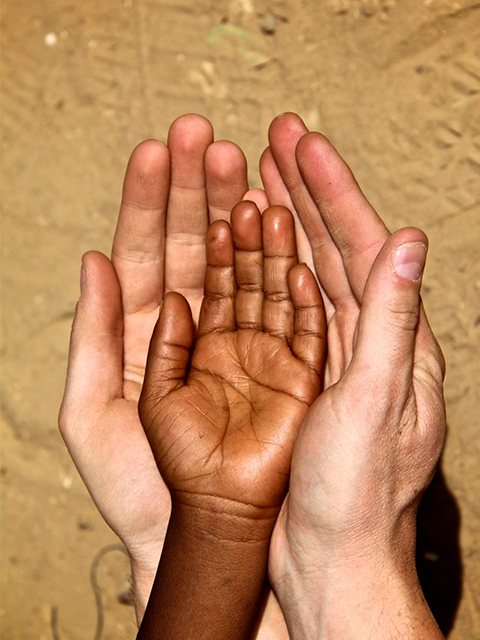 Two hands holding a kids hands