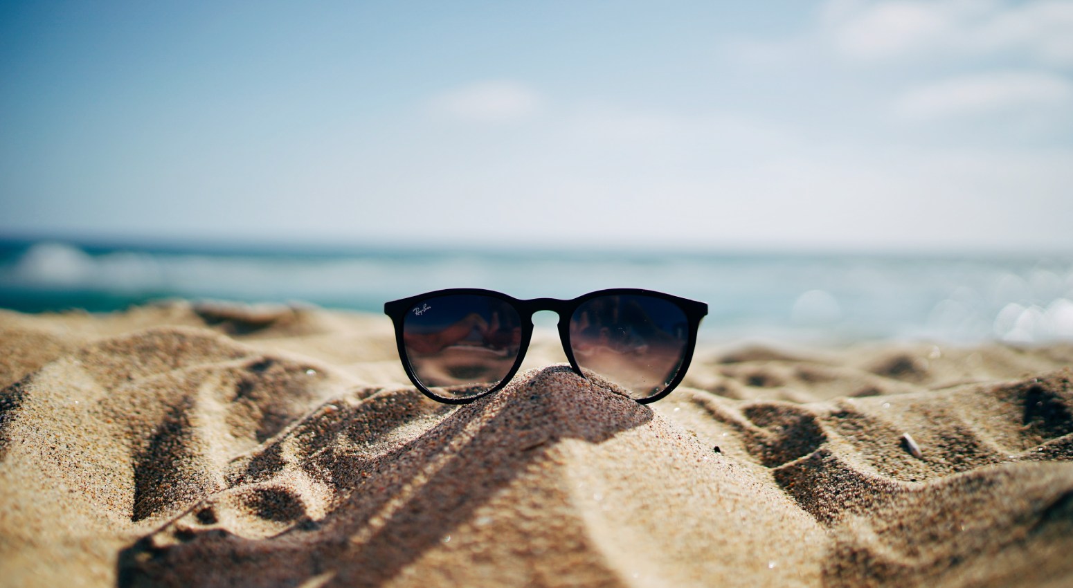 Sunglasses on a sandy beach.