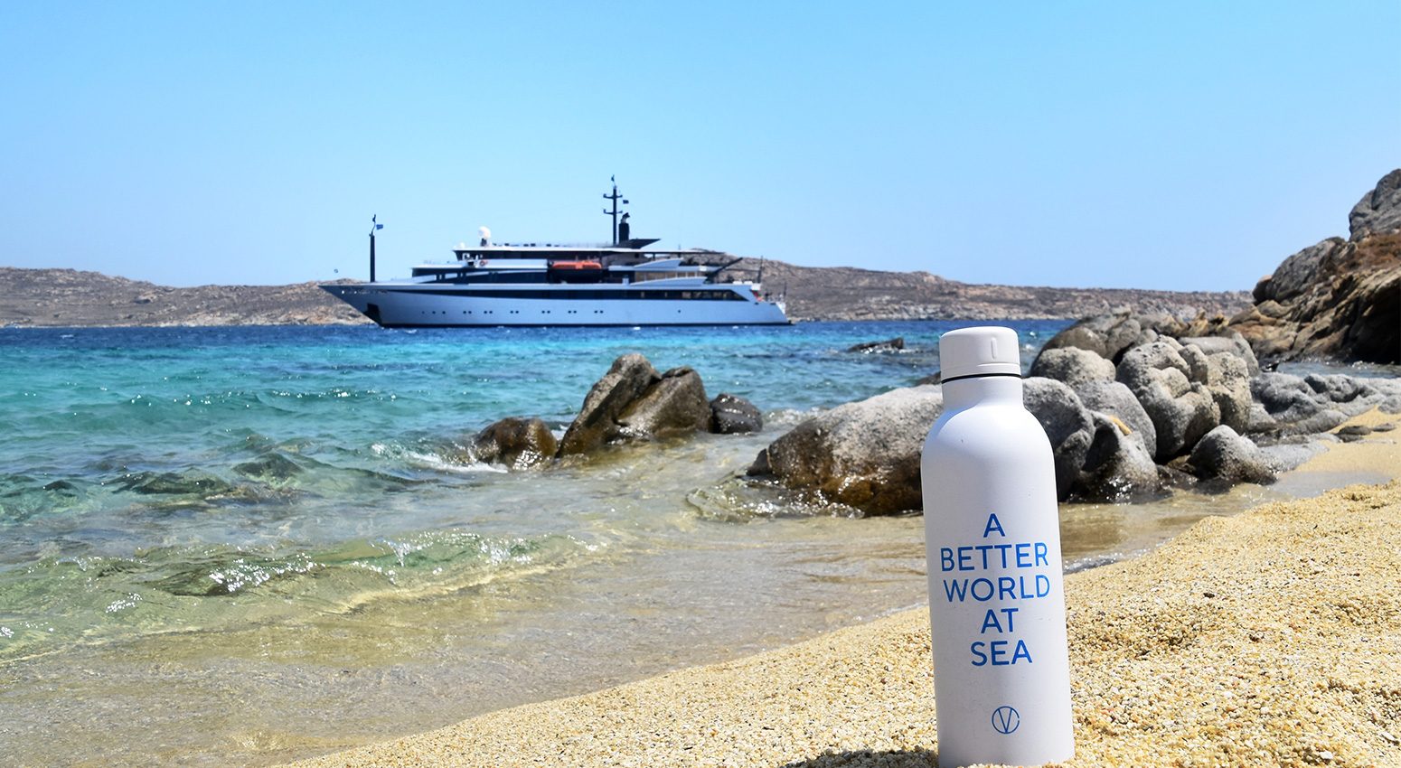 A water bottle on the beach with the text "A better world at sea" printed on it.